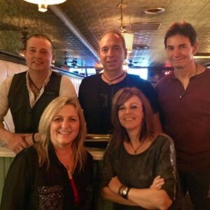 three men and two woman sitting