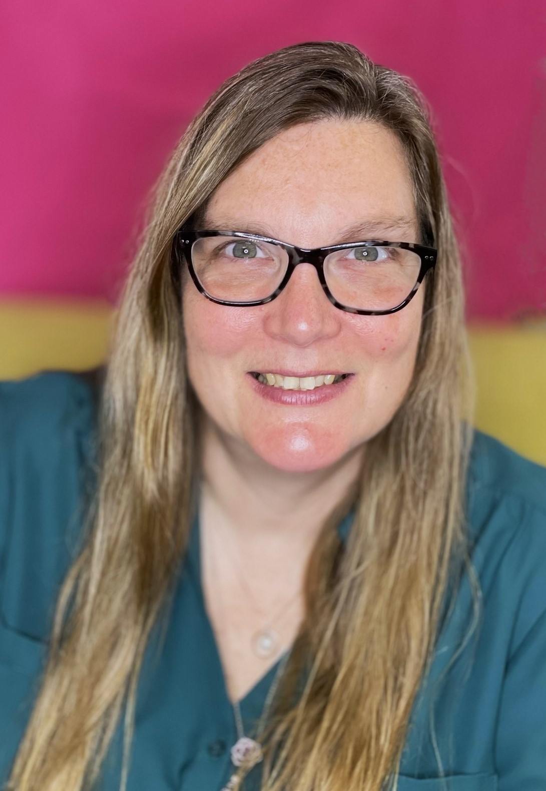 a woman with glasses is smiling for the camera