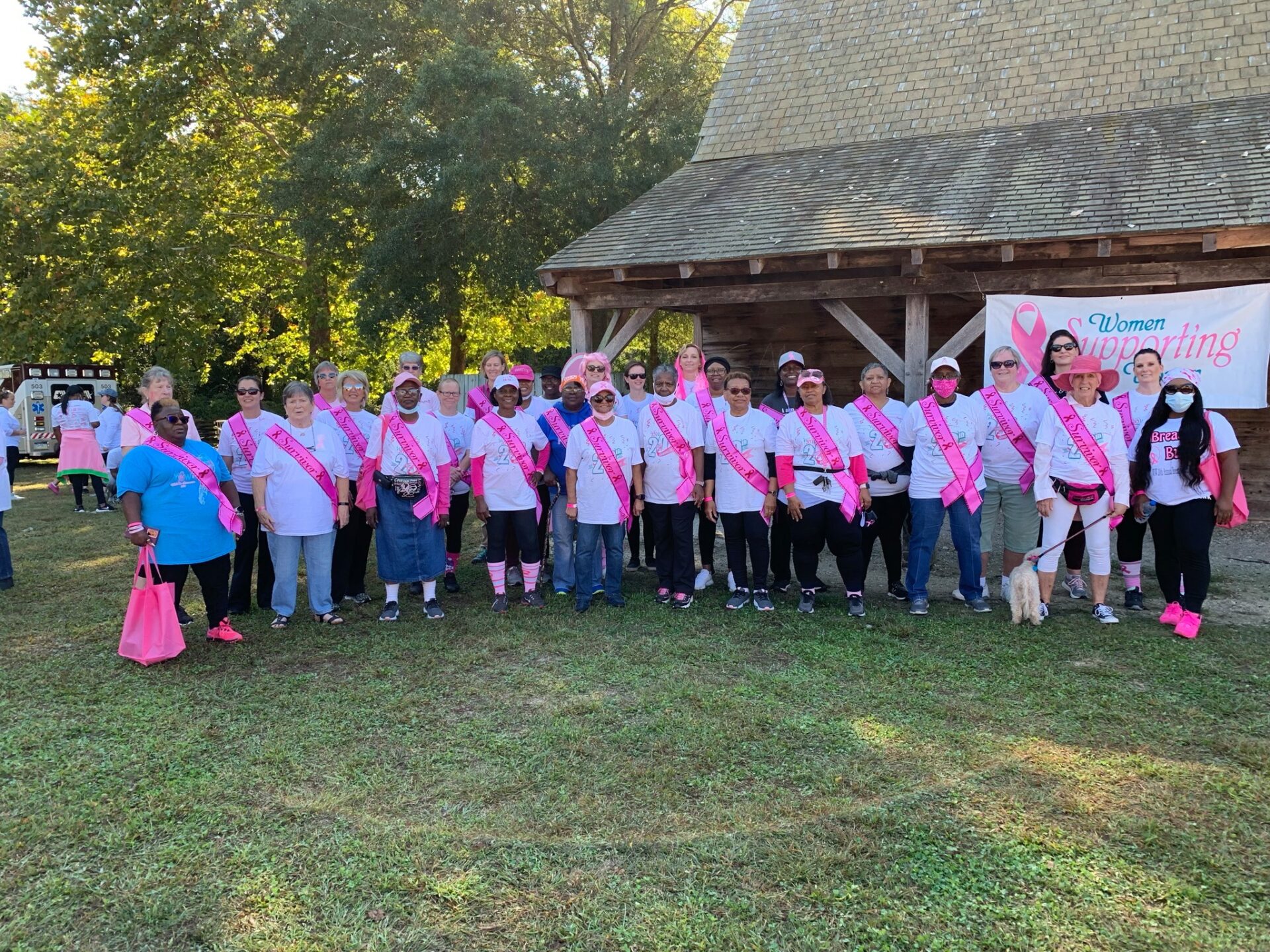 a group of people with pink ribbon on their backs