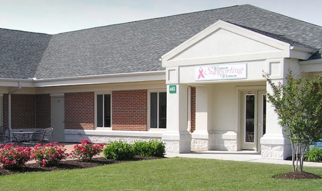 a building with flowers in the front and landscaping around it