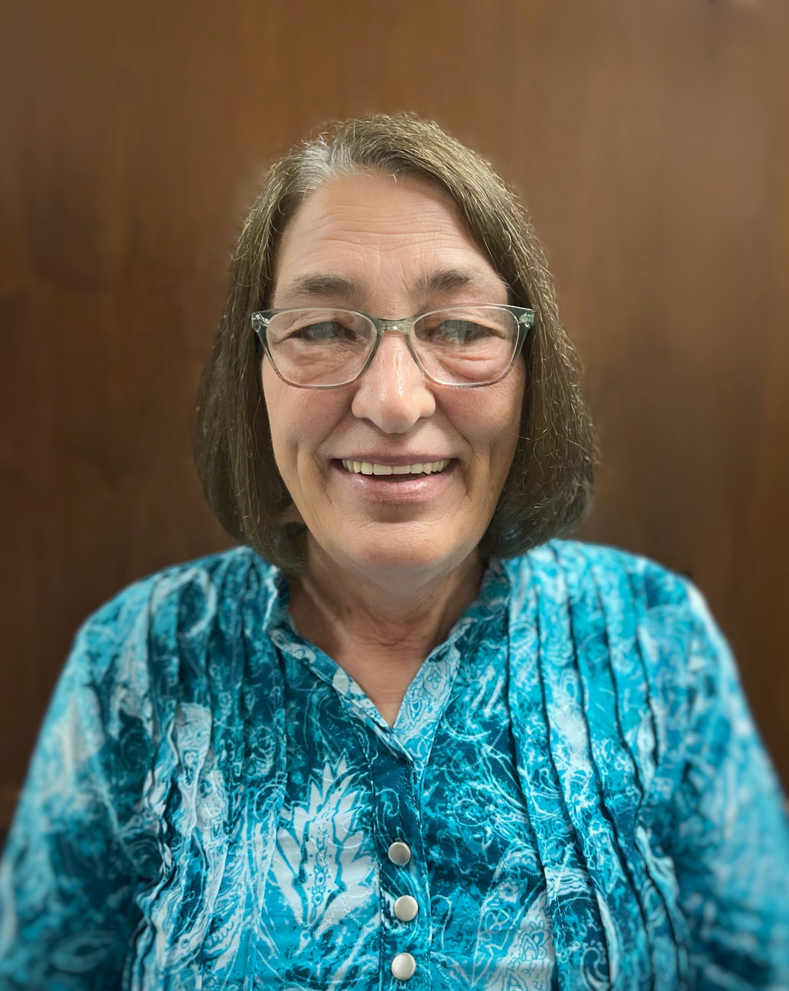 a woman wearing glasses and a blue shirt