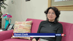 a woman is sitting on a pink couch