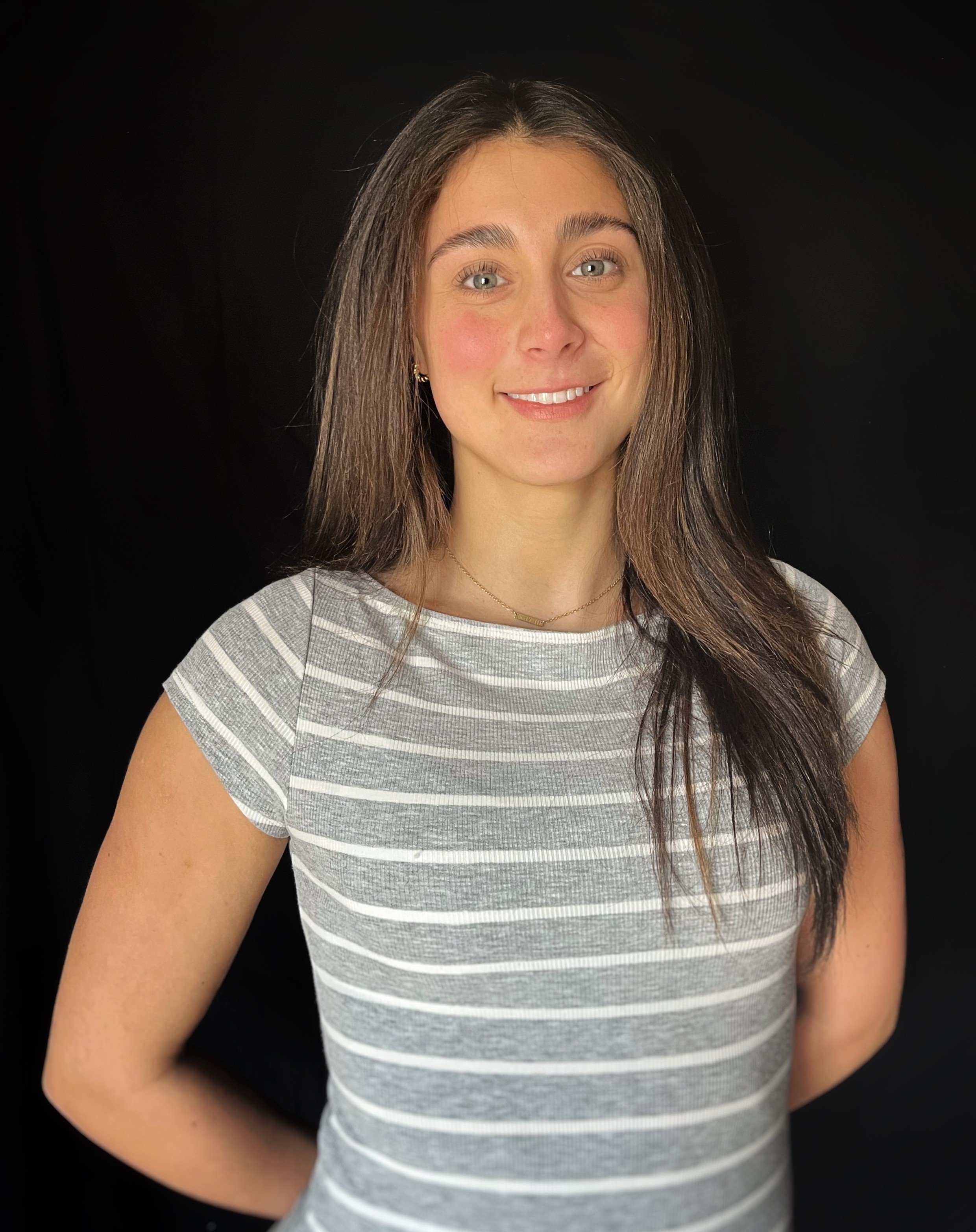 a woman standing in front of a black background