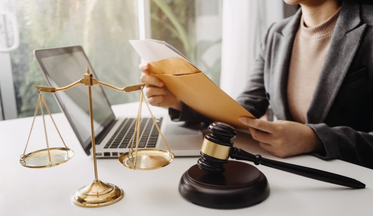 Business and lawyers discussing contract papers with brass scale on desk in office. Law, legal services, advice, justice and law concept